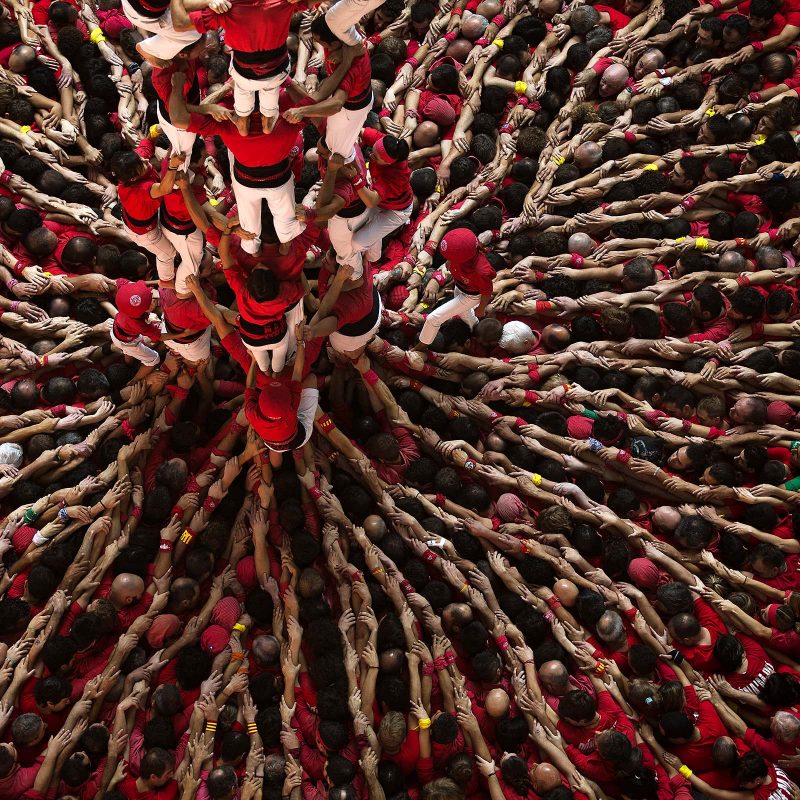 Members of the Castellers Joves Xiquets de Valls try to complete their human tower during the 25th Human Tower Competition in Tarragona, Spain.
